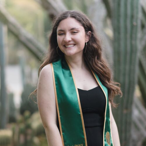 A smiling woman with a green graduate sash from Cal Poly's class of 2021